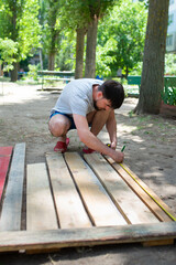 A man measures wooden planks with a construction tape measure