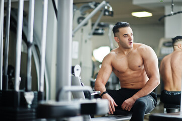 Fototapeta na wymiar Muscular arab man training in modern gym. Fitness arabian men with naked torso doing exercises .