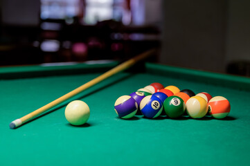 Colorful billiard balls and cue on a green table. billiard game in the club. snooker,