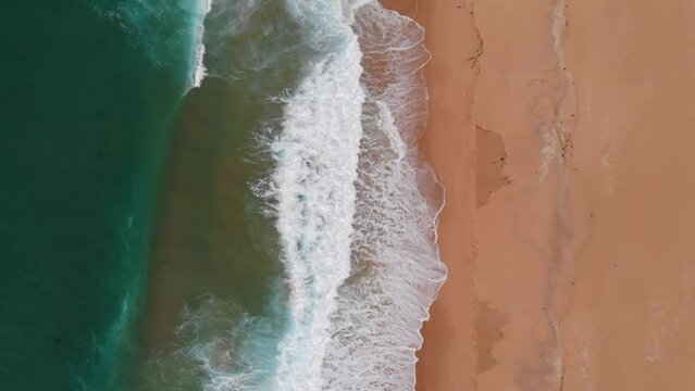 Aerial Top Down View of Beautiful Sandy Beach, Green Water Ocean and Waves Crashing on Sea Shore