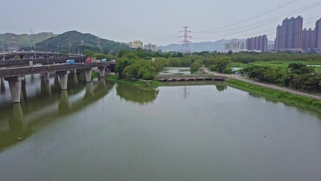 A dynamic aerial footage moving towards a highway above waters in Yuen Long in Hong Kong. Yuen Long Highway is an expressway connecting Au Tau in Yuen Long and Lam Tei in Tuen Mun of New Territories.