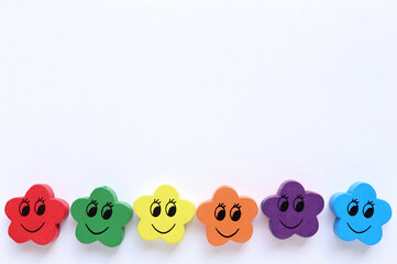 Close up of flower shaped wooden buttons on white background with empty space for text. Concept symbol LGBT. Pride Month. Love, human rights.