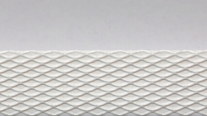White cardboard or paper texture with patterned strip of plastic. Horizontal rough textured empty background