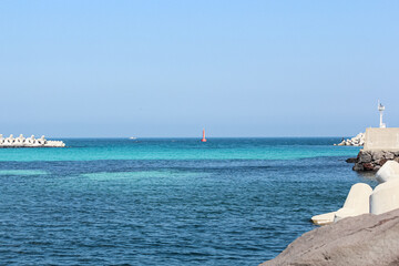 Fototapeta premium The blue sea under the blue sky as seen from the breakwater on a fine day. horizon
