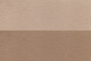 Texture of craft brown and beige paper background, half two colors, macro. Structure of vintage umber cardboard.