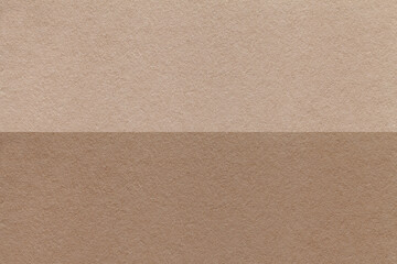 Texture of craft brown and beige paper background, half two colors, macro. Structure of vintage umber cardboard.
