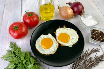 Fried eggs with vegetables, spices and herbs on light wooden background. Traditional European or Asian breakfast. - 512530859