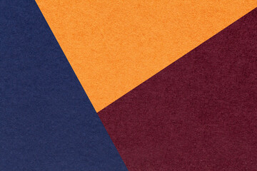 Fototapeta premium Texture of craft navy blue, orange and red shade color paper background, macro. Structure of abstract wine cardboard