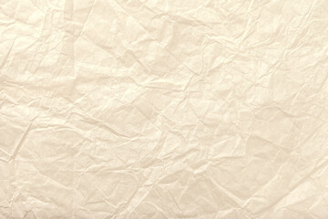 Texture of crumpled light beige wrapping paper background, macro. Pearl cream old craft backdrop