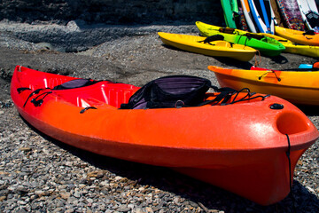 Kayak on the rocky shore of the sea, lake. Tourist tours rental on a boat with a paddle.