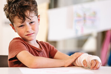 Boy suffering from pain in broken arm