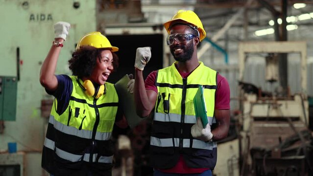 Happy successful winner and high fives. Woman worker wearing safety goggles control lathe machine to drill components. 