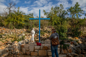 Woman praying on Apparition Hill, Medjugorje, Bosnia & Herzegovina