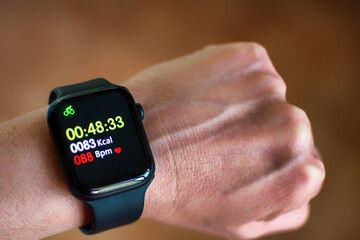 Close-up of a watch displaying calories and beats per minute. Anonymous man wearing a digital smart...