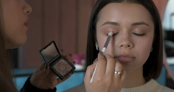 Close Up Female Make Up Artist Working with Client Eyelid, Young Woman at Procedure in the Beauty Salon