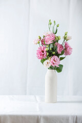 Pink lisianthus flowers in white vase