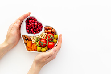 Hands with heart shaped dish of healthy diet food