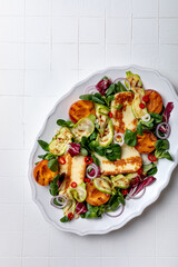 Grilled apricot and zucchini salad with halloumi and mustard dressing. Fresh summer gourmet salad on white background