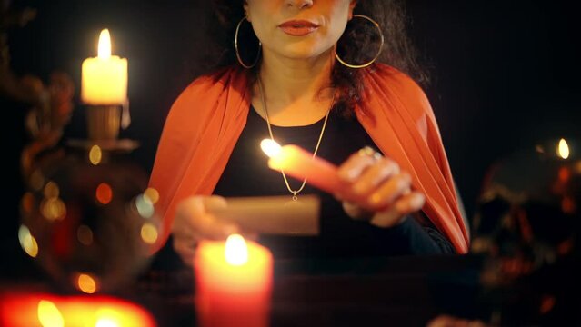 Female psychic moving burning candle over photograph, reading client's fate