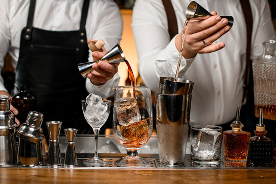 great view on mixing cup with ice and shaker cups on the bar counter into which the bartenders pour the drinks