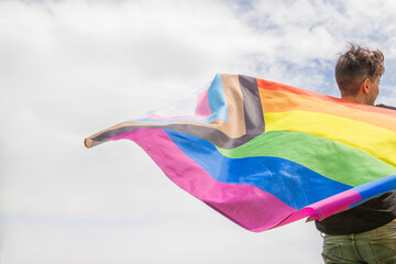 Pride month. Young lesbian girl waving the lgbtiq+ flag on the pride day. Celebrating the lgbt lesbian women rights.