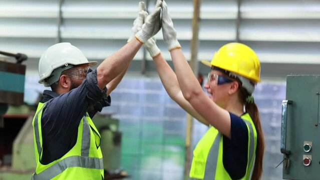 Unity and teamwork concept. team standing hands together. Professional mechanical engineering hispanic male operate lathe machine with apprentice female working at metal factory workshop.