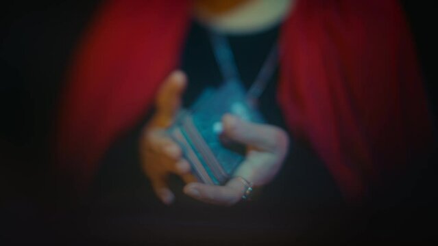 Female fortune-teller shuffling and laying out tarot cards, dream-like effect