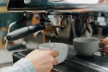 Tableau sur aluminium  Pouring coffee flow from a professional machine into a cup. The barista makes a double espresso using a filter holder. Flowing fresh ground coffee. Drinking roasted black coffee in the morning  © Guys Who Shoot