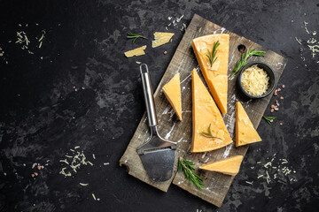 Parmesan cheese on a wooden board, Hard cheese, olives, rosemary and metal grater. place for text,...