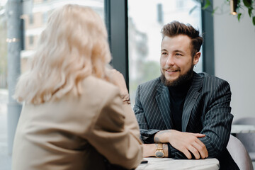 couple a young family spends time in a coffee shop, joking and smiling