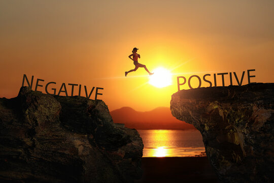 A woman jump through the gap between Negative to Positive on sunset.