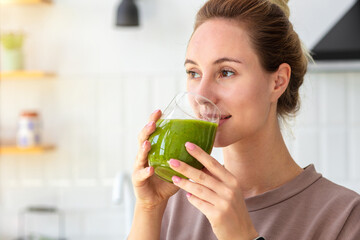 Healthy lifestyle, diet, weight loss concept. Portrait of woman drinking green smoothie close-up. Healthy food, breakfast. Vegetarian, vegan food - obrazy, fototapety, plakaty