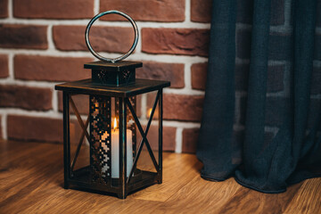 iron lamps with a burning candle near the Christmas tree