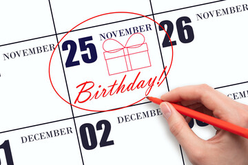 The hand circles the date on the calendar 25 November, draws a gift box and writes the text Birthday. Holiday.