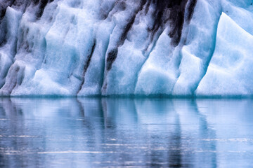 Detail of the front surface of the Fjalljokull glacier reflected in the Fjallsarlon glacial lagoon.