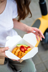 woman with scooter eating asian food