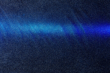 On a dark blue rough background in fine grain, a gradient light blue horizontal beam of light