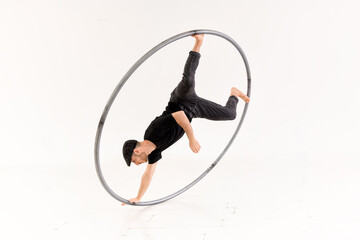 Acrobat performing trick with cyr wheel