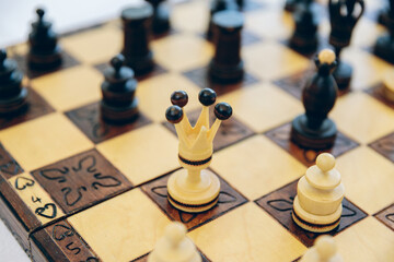 Antique handmade carved chess.Chess pieces on a high-quality chess board on a bright table in a...