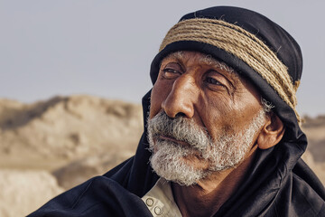 Portrait of an old Arab man with a sly expression.