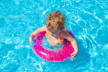 A child swims in a pool with a circle. Selection focus.