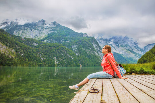 Woman enjoys nature at a mountain lake in the Alps.
