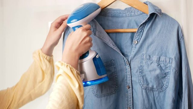 Beautiful steamer for clothes, vertical iron. concept of quick and easy ironing. woman irons shirt with an iron