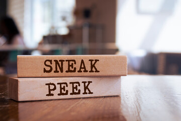 Wooden blocks with words 'SNEAK PEEK'.