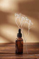 Nature cosmetic in glass bottle and shadow on beige background. Face and body care spa concept....