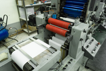 Paper web feeding and alignment unit in a roll rotary flexographic printing machine. Equipment for printing house. Selective focus