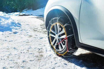 Car wheel with winter chains for snow and ice road on it