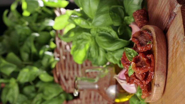Dried tomatoes in olive oil and capers in piala, basil next to the product. Leaking oil. Traditional Italian and Spanish appetizer for aperitivo and toast.4k footage.Vertical format, for social posts