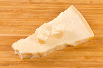 Pieces of the hard cheese on a wooden surface
