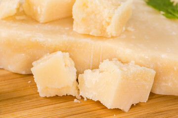 Hard cheese on wooden surface, close-up in selective focus